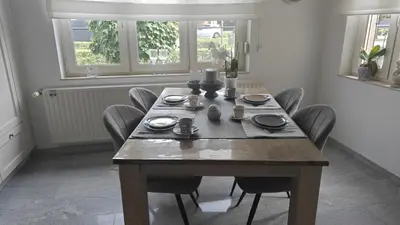 a dining room with a wooden table and chairs at holiday home Zonnestraal in Zonhoven