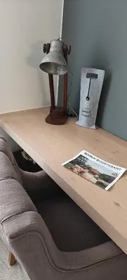 a coffee table with a lamp and a book on it at holiday home Zonnestraal in Zonhoven