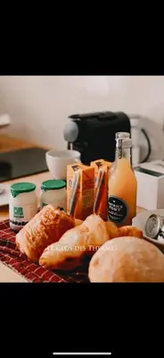 a table topped with bread and bottles of orange juice at Clos des Thermes-Zanzibar in Liège