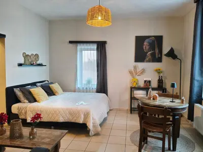 a bedroom with a bed and a table in it at De Smokkelhoeve in Riemst