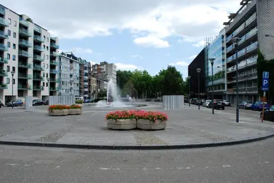 a street with a fountain in the middle of a city at Le 21 - Appart 3 chambres - centre de Liège in Liège