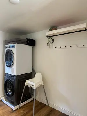 a laundry room with a washing machine and a chair at Residence Saint Lambert in Plombières