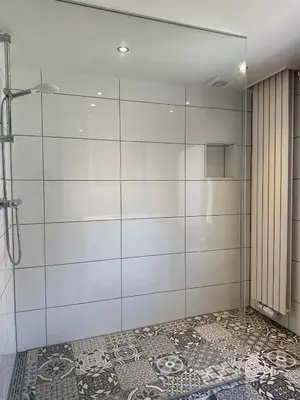 a shower with a glass door in a bathroom at Residence Saint Lambert in Plombières