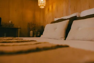a bedroom with a bed with pillows and a chandelier at Essential by cin in Zonhoven