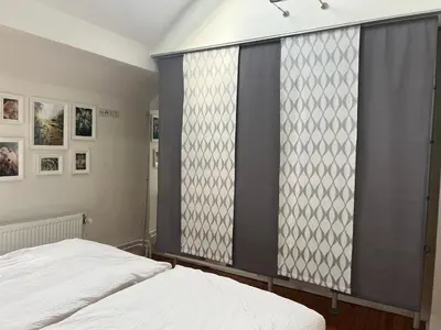a bedroom with a bed and a large window at Cottage CaLoMa in Eupen