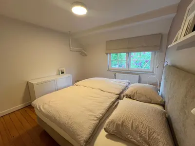 a bedroom with two beds and a window at Cottage CaLoMa in Eupen