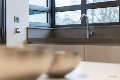 a kitchen counter with a sink and a window at 14 beds, 20p, 2 bath-, 1 livingroom in Houthalen-Helchteren