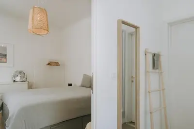 a white bedroom with a bed and a ladder at 1 bedroom apartment in Liège center, Place du Marche - 3rd floor in Liège