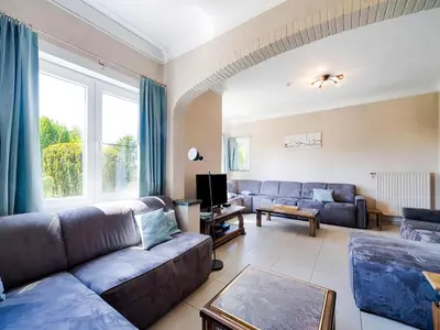 a living room with a couch and a tv at Villa Borgloon with Blossom Views and Jacuzzi in Borgloon