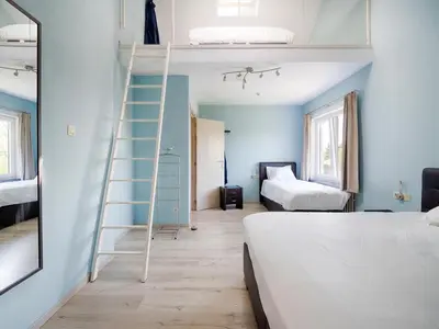 a room with two beds and a ladder in it at Villa Borgloon with Blossom Views and Jacuzzi in Borgloon