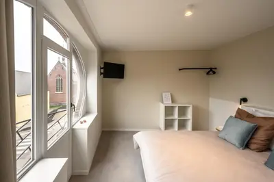 a bedroom with a bed and a window at Borgraaf - Fruitzicht in Borgloon