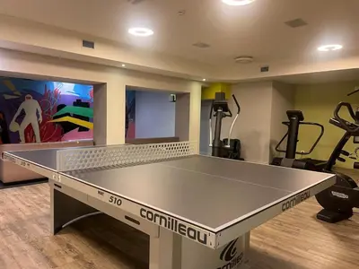 a ping pong table in a room with a gym at Le spot Central securisé sauna rooftop in Liège