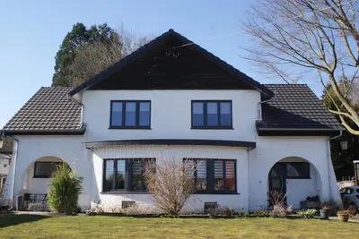 a white house with a black roof at Bizette67 in Herstal