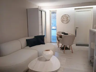 a living room with a white couch and a table at Studio Eik 105 at the pool in nature domain in Houthalen-Helchteren