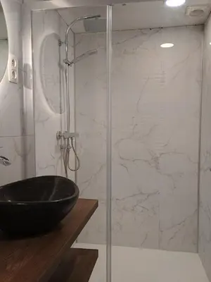 a bathroom with a glass shower with a black sink at Studio Eik 105 at the pool in nature domain in Houthalen-Helchteren