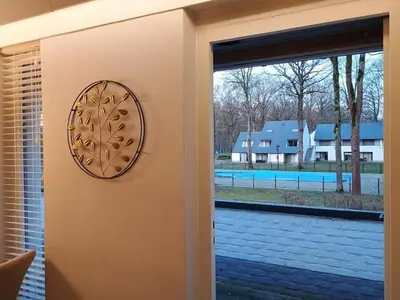 a door with a window looking out at a pool at Studio Eik 105 at the pool in nature domain in Houthalen-Helchteren