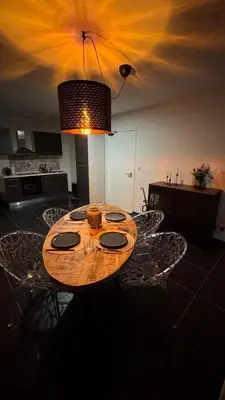 a dining room table with chairs and aendant light at Loft Ardent in Liège