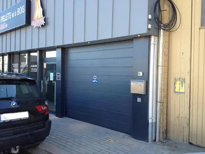 a blue garage door with a car parked next to it at Le Gate One in Herbesthal
