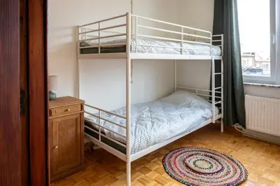 two bunk beds in a room with a window at Chez Marraine Suzanne in Liège