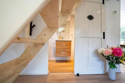 a staircase in a house with a vase of flowers at Boshuisje met jacuzzi in Lanaken