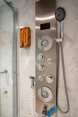 a shower with a shower head in a bathroom at Boshuisje met jacuzzi in Lanaken