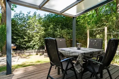 a patio with a table and chairs on a deck at Boshuisje met jacuzzi in Lanaken