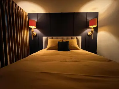 a bedroom with a large bed with two lamps at Garden Street - Antiquity Blue in Lommel