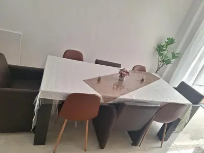 a dining room table with a white table and chairs at Tc home in Liège