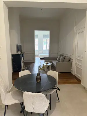 a living room with a table and chairs and a couch at Luxury Riverfront Apartment near La Meuse in Liège