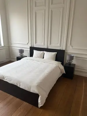 a bedroom with a large white bed with two lamps at Luxury Riverfront Apartment near La Meuse in Liège