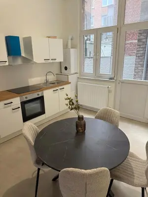 a kitchen with a table and chairs in a kitchen at Luxury Riverfront Apartment near La Meuse in Liège