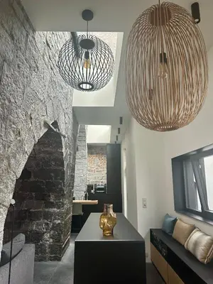 a living room with two chandeliers and a table at La Tour in Liège