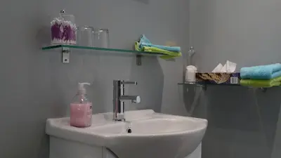 a bathroom with a sink and a bottle of soap at Aux Cosmos in Olne