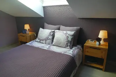a bedroom with a bed with pillows and two lamps at Aux Cosmos in Olne