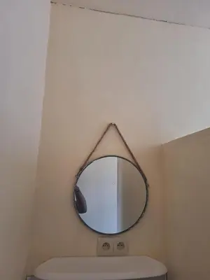 a mirror hanging above a toilet in a bathroom at Maison sympathique in Liège
