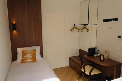 a bedroom with a bed and a desk and a table at Door9 Hasselt - Digital Hotel & Restaurant in Hasselt