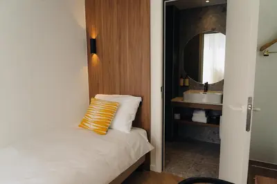 a small bathroom with a bed and a sink at Door9 Hasselt - Digital Hotel & Restaurant in Hasselt