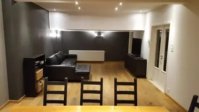 a living room with a black couch and chairs at Vakantiewoningen De Jud in Maasmechelen