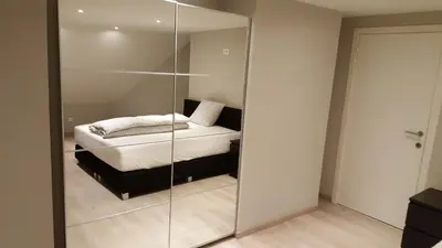 a bedroom with a bed and a glass wall at Vakantiewoningen De Jud in Maasmechelen