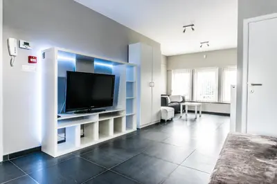a living room with a flat screen tv on a wall at Vakantiewoningen De Jud in Maasmechelen