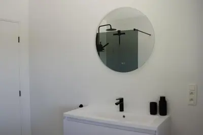 a bathroom with a mirror over a white sink at Vakantiewoning Ten Huyze Bucholt met tuinsauna in Bocholt