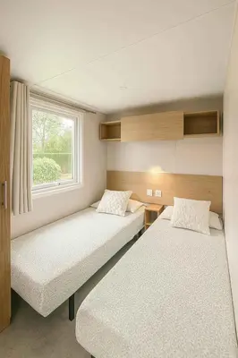 two beds in a small room with a window at Family chalet Kinrooi - Papillon Kinrooi in Kinrooi