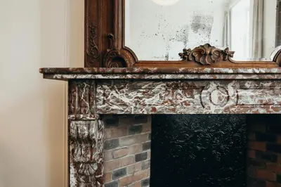 an old fireplace with a mirror on top of it at Champagne, Parc de la Boverie by WelcHome in Liège