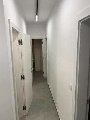 a hallway with white doors and a mirror in a room at Heel Appartement 90m2 met 2 slaapkamers woonkamer Keuken badkamer privé garage in Sint-Truiden