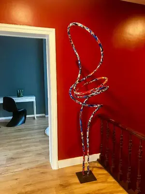 a metal sculpture of a snake against a red wall at Crossborder Nest - Appartement de standing proche du circuit SPA-FRANCORCHAMPS et des HAUTES-FAGNES in Verviers