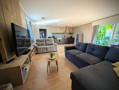 a living room with a blue couch and a tv at Landbæne in Lommel