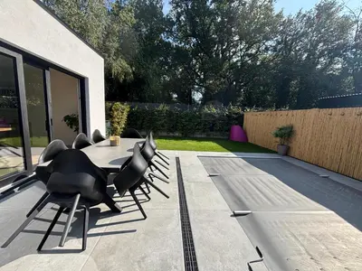 a patio with a table and chairs in a backyard at Home Terboekt in Genk