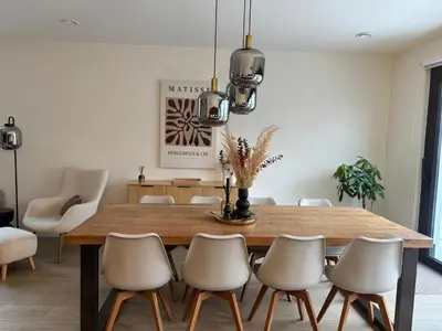 a dining room with a wooden table and chairs at Home Terboekt in Genk