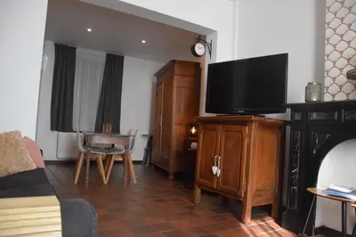 a living room with a flat screen tv on a wooden cabinet at La Belle Échappée à Fléron in Fléron