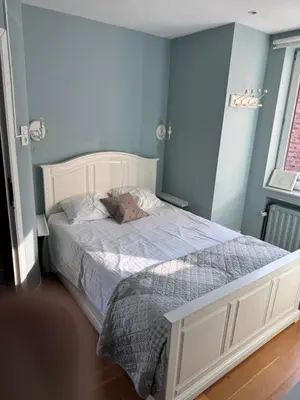 a bedroom with a bed with a blue wall at Bel appart - Tilff in Tilff